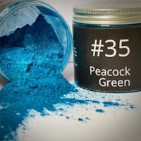 a jar of peacock green powder next to a jar