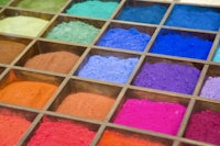 a display of colored powders in a wooden box